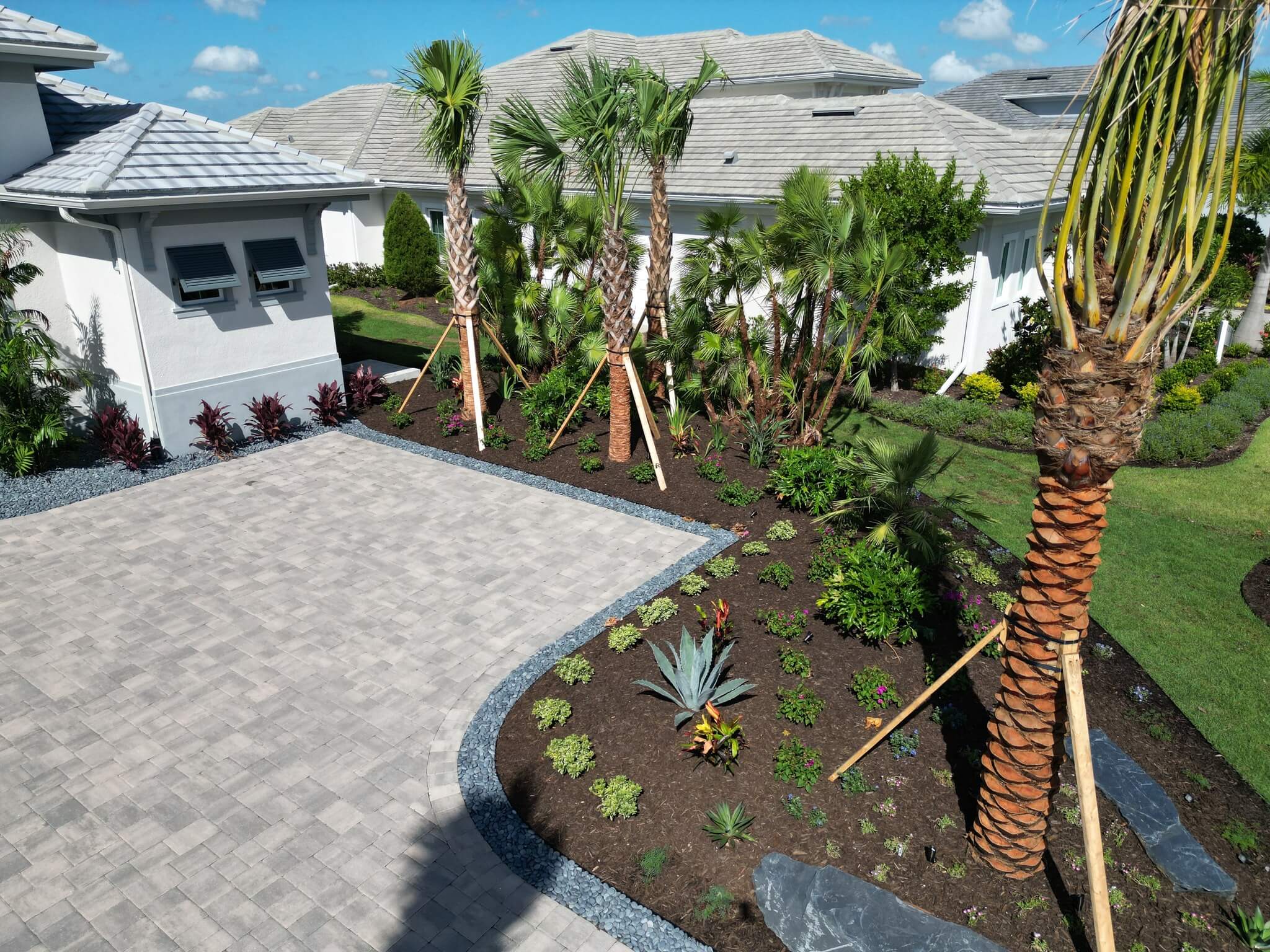 Landscape installation Lakewood Ranch with clean edging and fresh mulch around palms