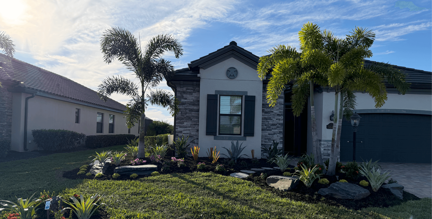 Landscaping in Palmetto, FL with palms, clean planting beds, and outdoor lighting