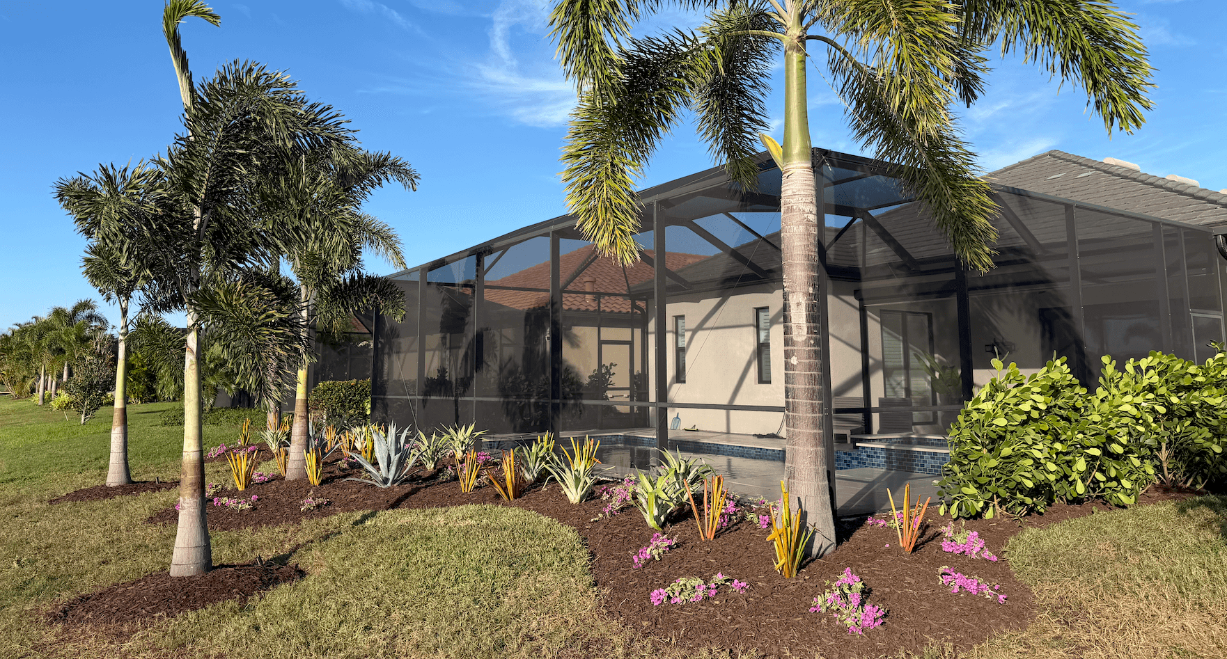 Landscaping in Parrish, FL with palms, fresh planting beds, and outdoor lighting